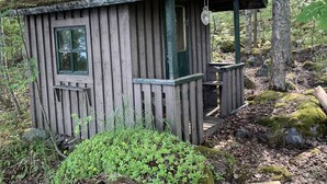A rustic wooden cabin with a small porch and a window. - Little Finland (Jyväskylä)