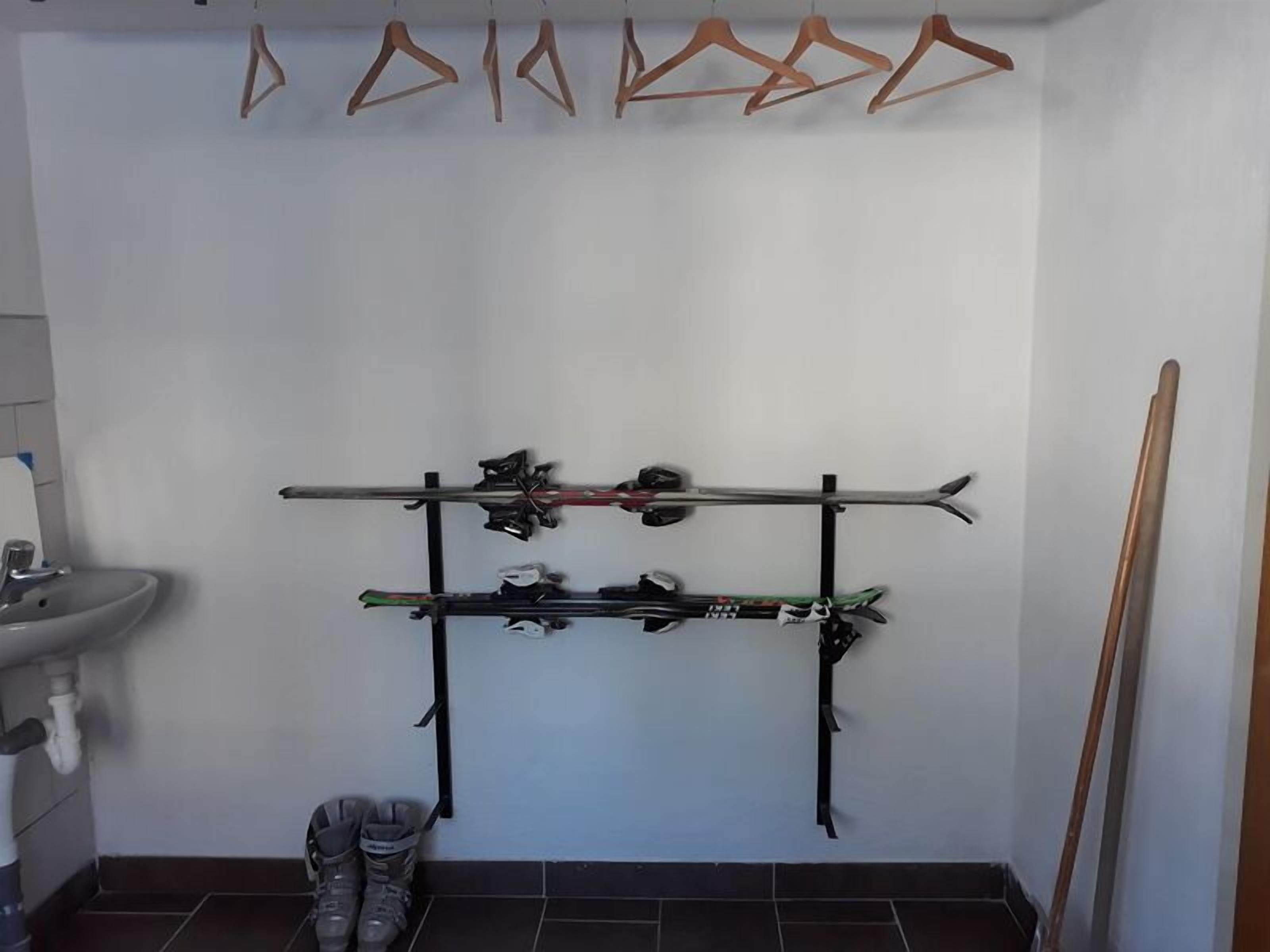 A ski rack with skis and poles in a bathroom.