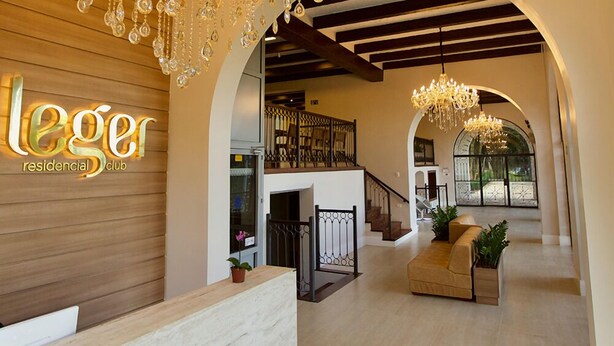 A spacious interior with a reception area, a staircase, and a seating area. - Residencial Sênior Club Leger (São Paulo)