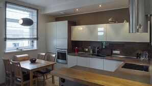Eine moderne Küche mit Holztisch, integrierten Geräten und einem großen Fenster.