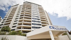 A high-rise hotel with a prominent "CAIRNS AQUARIUS" sign, multiple balconies, and a modern architectural design. - Cairns Ocean View Apartment in Aquarius (Cairns)