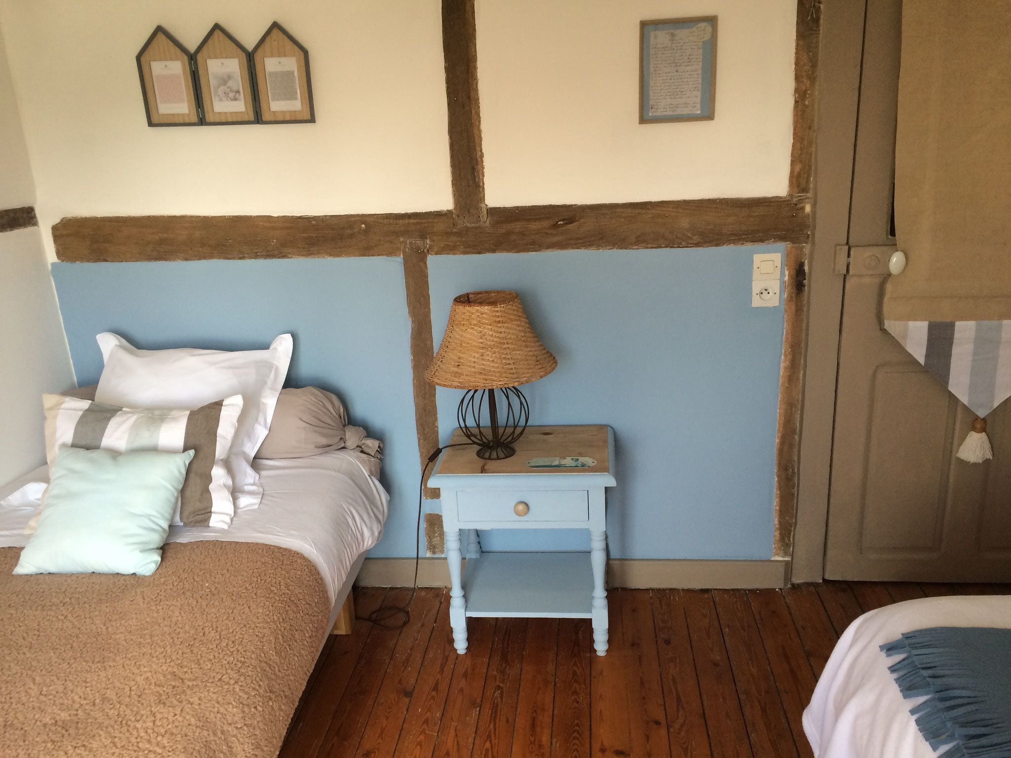 Un dormitorio con una cama, una mesita de noche con lámpara y una puerta.