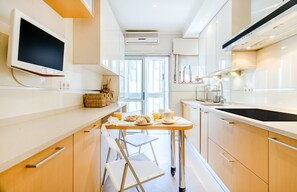 Una cucina moderna con un tavolo da pranzo, sedie e una TV montata a parete.