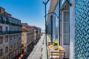 A balcony with a table, chairs, and a vase of flowers. - Life is Good in Lisbon Baixa Apartment (Lisbon)