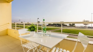 A balcony with a white table and chairs, a bottle of Chivas, and a potted plant. - São Félix Ocean Views Apartment (Vila Nova de Gaia)