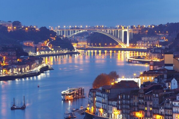 A river with a bridge, boats, and buildings along the banks.