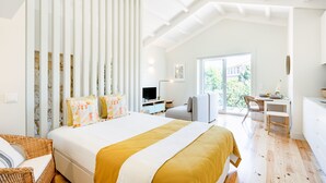 Quarto com uma cama grande, uma escrivaninha e uma cadeira.