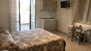 A bedroom with a bed, a desk with a chair, a sink, and a TV mounted on the wall. - B&B Tra Gli Ulivi (Rocca San Giovanni)
