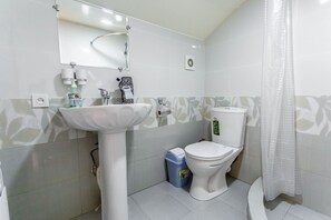 A bathroom with a white sink, toilet, and shower curtain. - Hotel Suzani Samarkand (Samarkand)