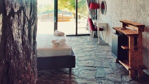 A rustic room with a stone floor, wooden ceiling, and a large window. - Rocas Roja Beach Hotel (Fethiye)