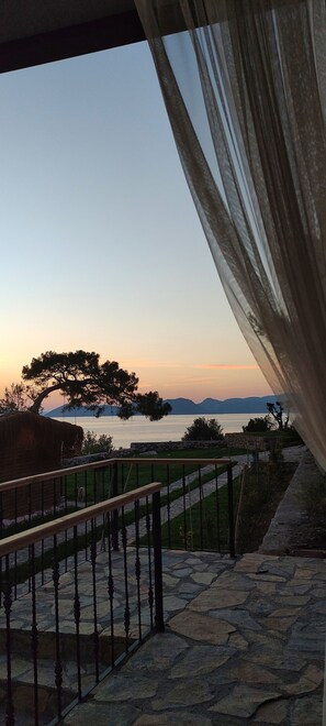 A stone staircase leading to a balcony overlooking a body of water with a tree and distant mountains. - Rocas Roja Beach Hotel (Fethiye)