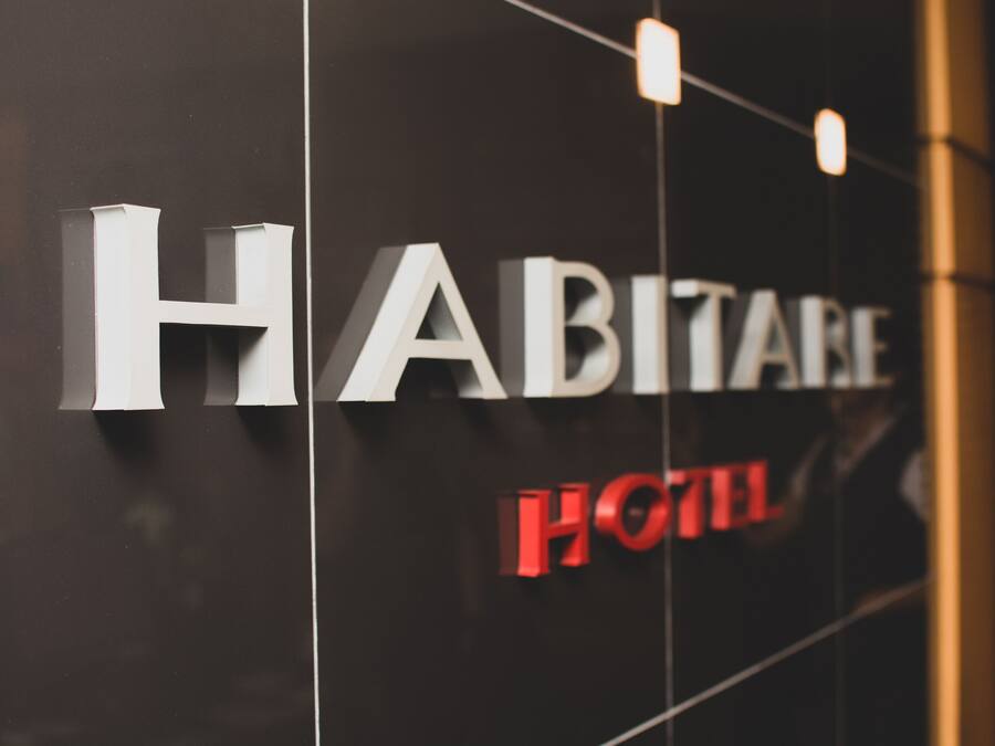 A hotel sign with the name "HABITAT" and "HOTEL" in large letters.