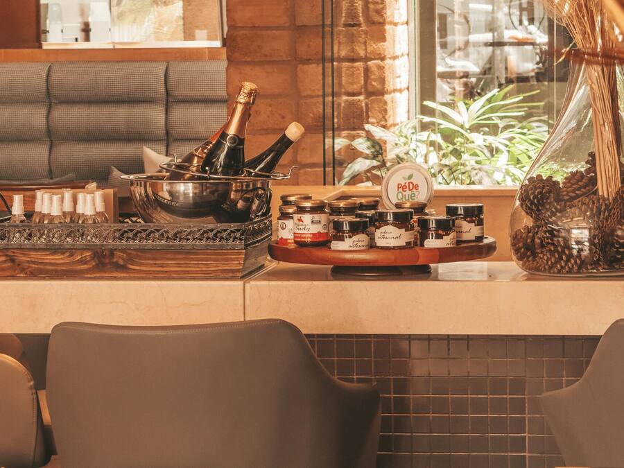 A bar area with bottles, a bowl of champagne, and jars of honey.