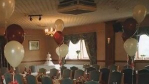 A banquet hall with rows of tables and chairs, balloons, and a chandelier. - Scottshotel (Pontypridd)