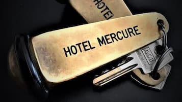 Due manubri dorati con inciso "HOTEL MERCURE" e "HOTEL", poggiati su una superficie nera.