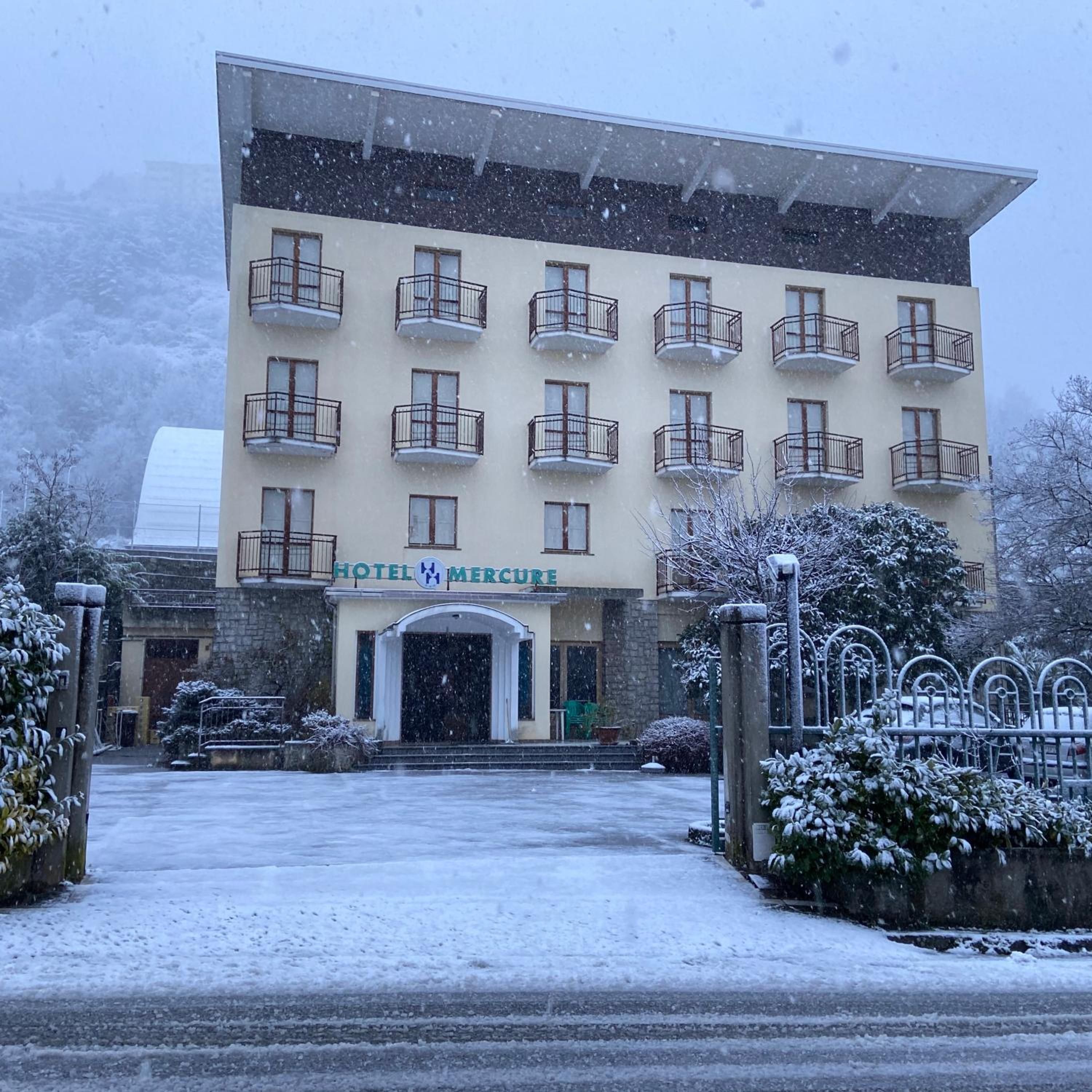 Un edificio di un hotel con numerosi balconi e un cartello con su scritto 'HOTEL MERCURUE'.