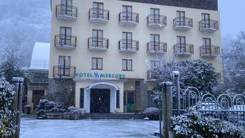 Un edificio di un hotel con numerosi balconi e un cartello con su scritto 'HOTEL MERCURUE'.