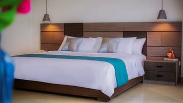 A neatly made bed with white linens and a teal accent, a wooden headboard, bedside tables with lamps, and a small decorative item on the nightstand.