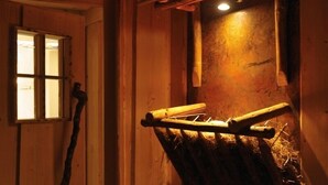 A rustic wooden interior with a window, a wooden beam structure, and a wall-mounted light fixture. - Hotel Molitors Mühle (Eisenschmitt)