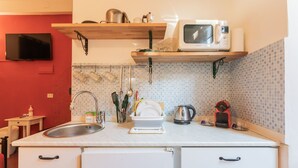 Une cuisine équipée d’un four à micro-ondes, d’un évier et de divers ustensiles.