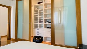 A bedroom with a bed, a wardrobe with multiple compartments, and a small table.