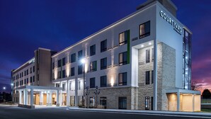 A Courtyard hotel with a modern design, featuring multiple floors, large windows, and a well-lit entrance. - Courtyard by Marriott Kansas City Olathe (Olathe)