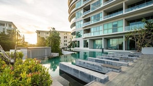 A modern building with a pool and outdoor seating. - The Ark By Veloche Group (Karon)
