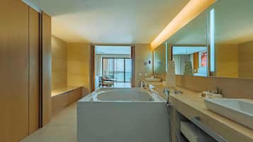 Un baño moderno con una bañera grande, dos lavamanos y un espejo amplio.