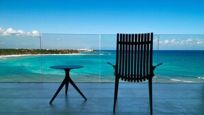 Un balcon offrant une vue sur des eaux turquoise et une côte lointaine.