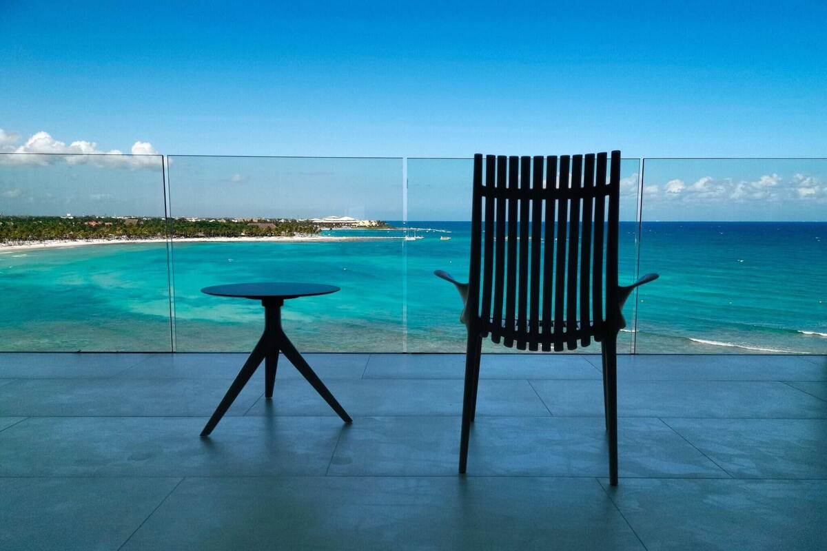 Ein Balkon mit Blick auf türkisfarbenes Wasser und eine ferne Küste.