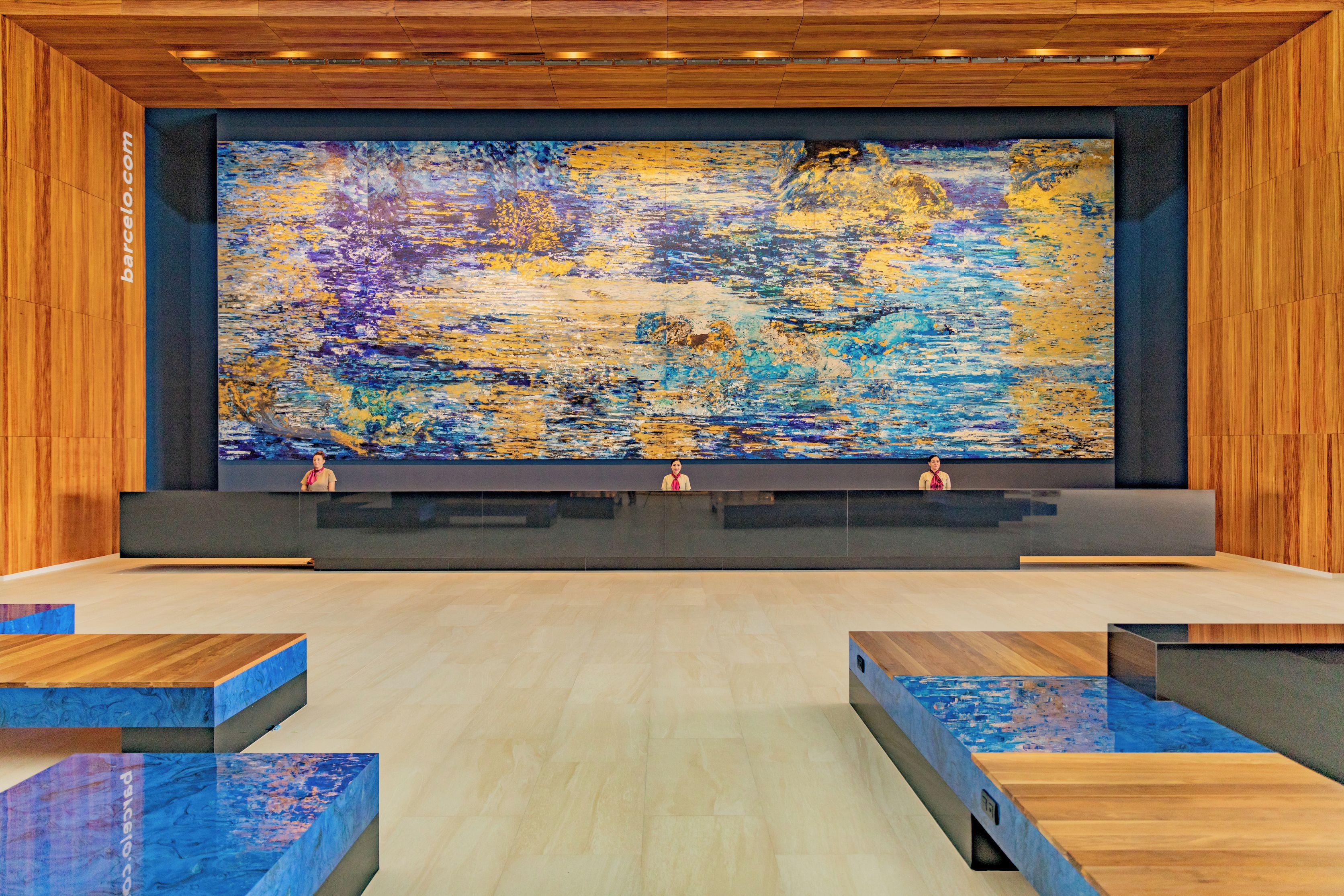 A reception area with a large abstract painting, wooden paneling, and a modern reception desk.