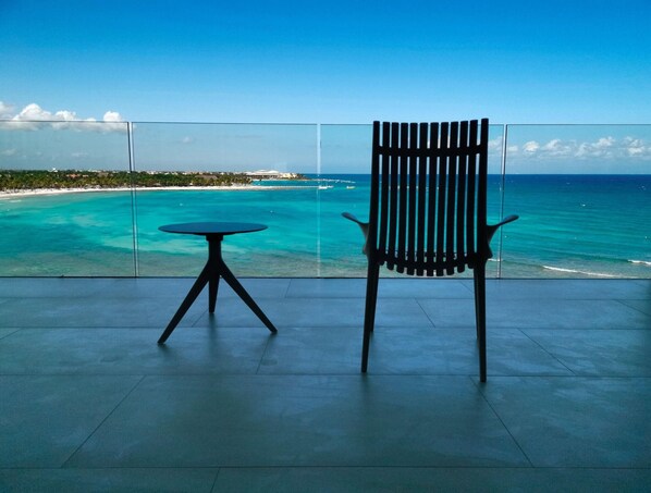 A balcony with a view of turquoise waters and a distant shoreline. - Barcelo Maya Riviera (Xpu-Ha)