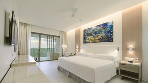 Una camera d'albergo con un letto grande, una scrivania, una sedia, una TV, un quadro e un balcone con vista.