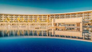 Un hotel con una piscina grande, varios pisos y un diseño arquitectónico moderno.