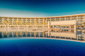 A hotel with a large pool, multiple floors, and a modern architectural design. - Barcelo Maya Riviera (Xpu-Ha)