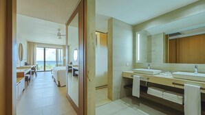 A hotel bathroom with a large mirror, two sinks, and a shower area. - Barcelo Maya Riviera (Xpu-Ha)