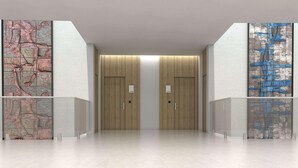 A modern hallway with two doors, each marked with a number. The walls are adorned with large, textured maps. - Barcelo Maya Riviera (Xpu-Ha)