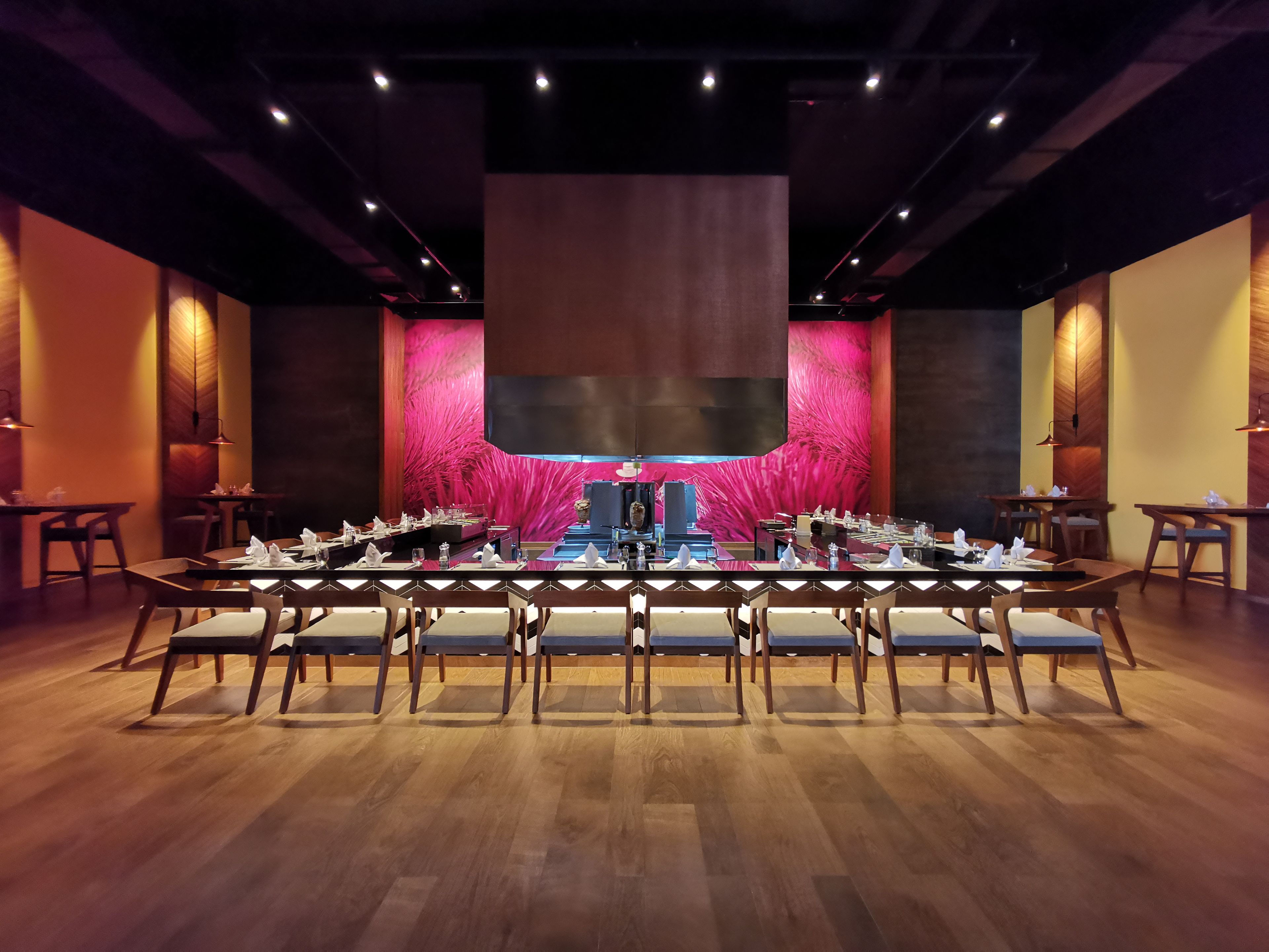 A conference room with a long table set for a meeting, surrounded by chairs.