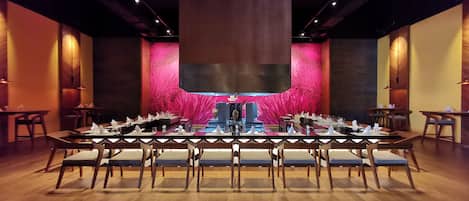 A conference room with a long table set for a meeting, surrounded by chairs.