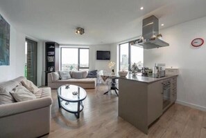 A modern apartment with a living room, dining area, and kitchen. - Stylish 1 Bedroom Apartment near London City (London)