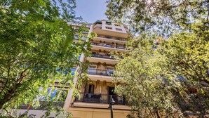 A multi-story building with balconies, surrounded by trees. - Sweett | Rocafort 604 (Barcelona)
