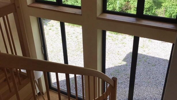 A staircase with wooden railings leading to a balcony with large windows overlooking a garden. - Vacation home at Süderdeich in Friedrichskoog (Friedrichskoog)