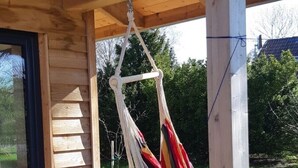 A wooden deck with a hammock hanging from a wooden beam. - Vacation home at Süderdeich in Friedrichskoog (Friedrichskoog)