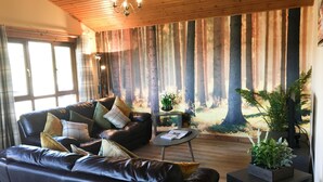 Een gezellige woonkamer met een leren bank, een salontafel en een groot raam.