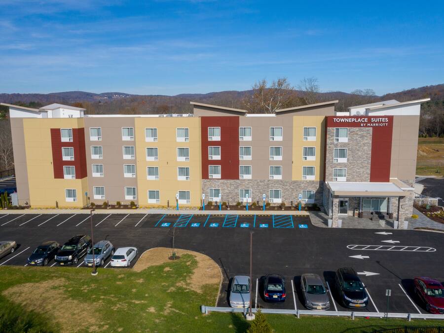 A multi-story hotel with a parking lot in front.