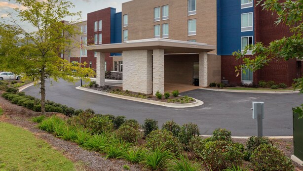 A modern building with a brick facade and a covered entrance area. - SpringHill Suites by Marriott Suwanee Johns Creek (Suwanee)