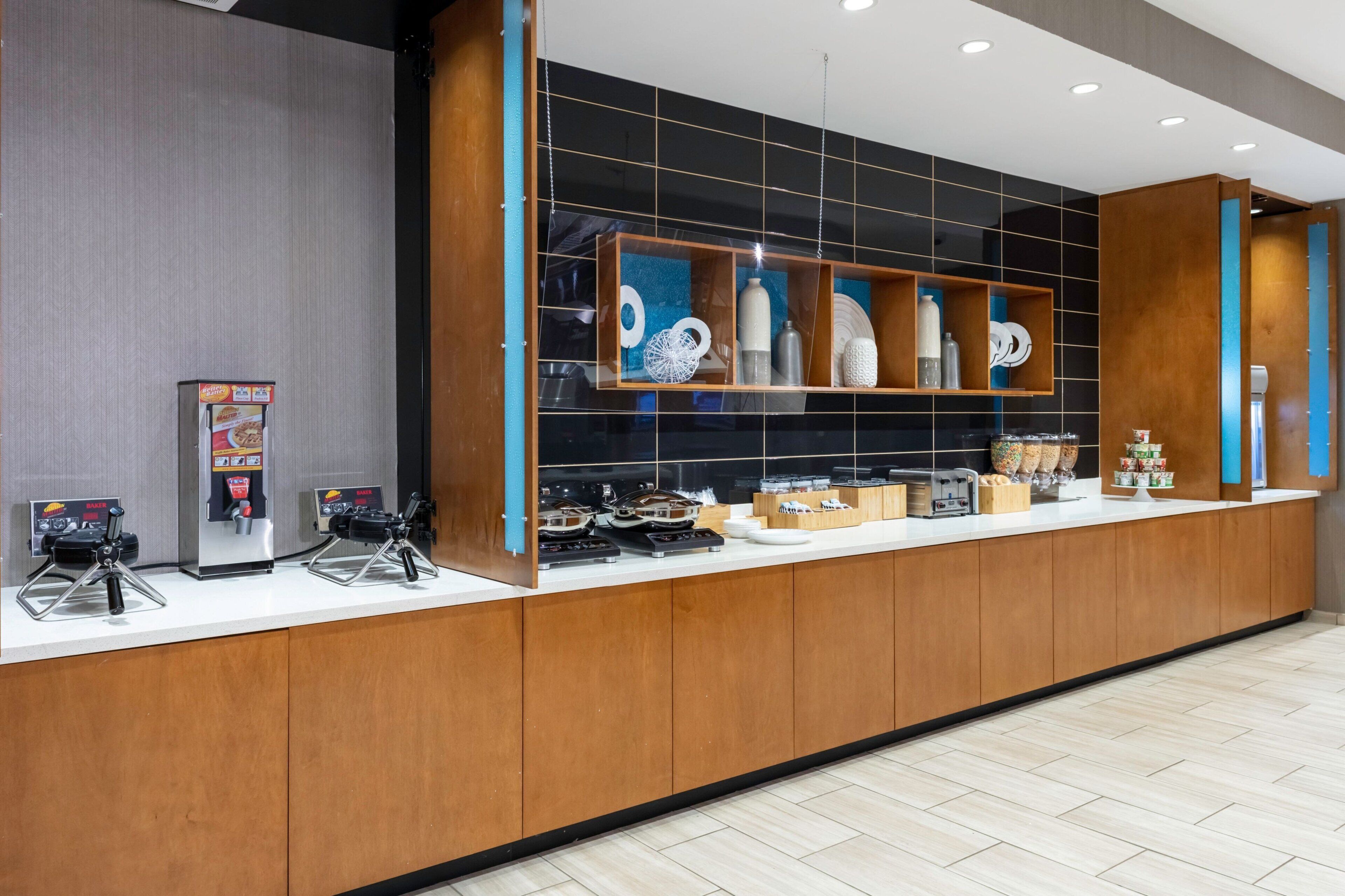 Een moderne receptiebalie met lange toonbank, koffieautomaten en een presentatie van diverse artikelen.