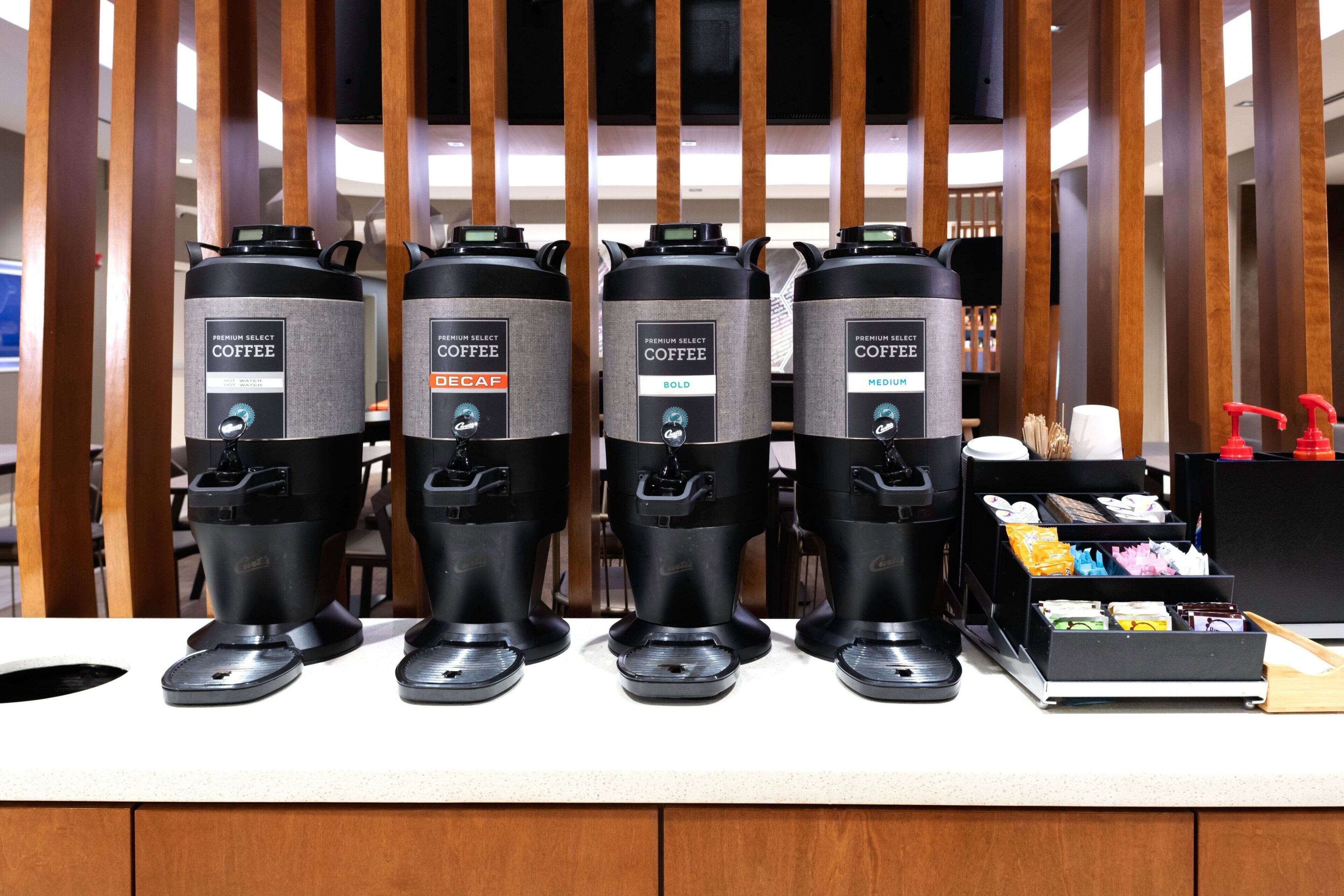 Four coffee dispensers labeled "Premium Select Coffee" with options "Bold" and "Medium" on a counter.