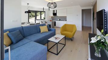 Una sala de estar moderna con un sofá seccional azul, un sillón amarillo y una mesa de centro.