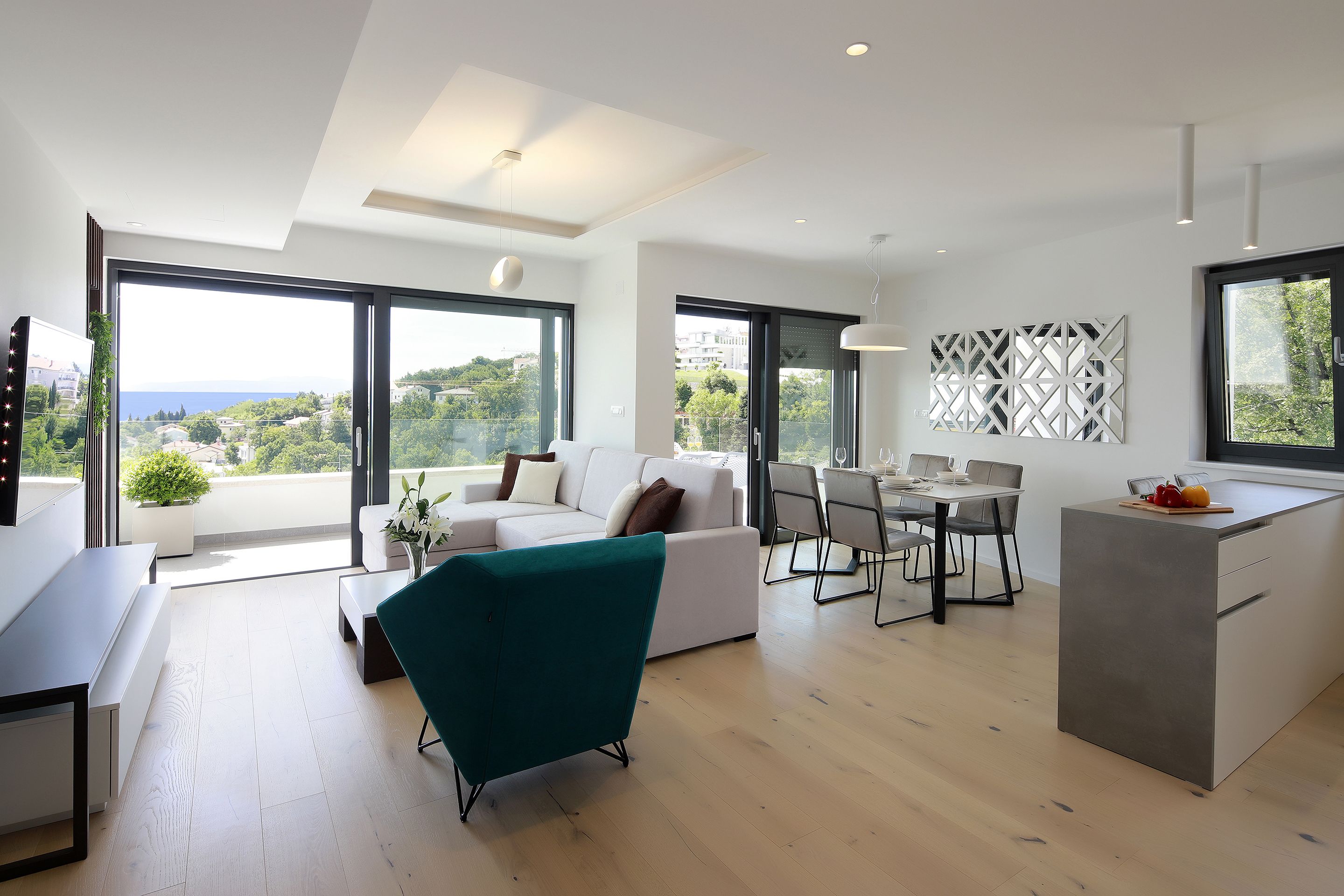 A modern living space with a sofa, dining area, and kitchen island.